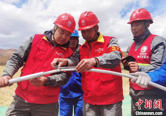 图为阿里与藏中电网联网工程包11标段项目部员工正在测量导线压接尺寸。 张弛 摄
