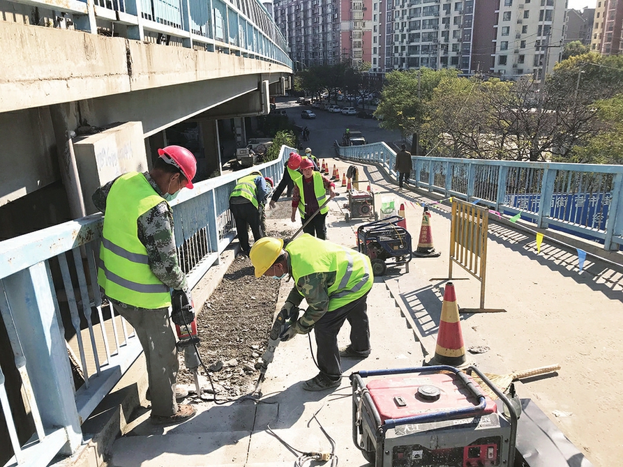 阶改坡 路更畅 经六路跨铁路桥通车16年后,辅道进行大改造上行方向左半幅阶梯改坡道,下行方向新建坡道